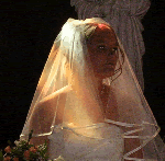 La mariée au coeur d'un rayon de soleil pénétrant les vitraux de l'église